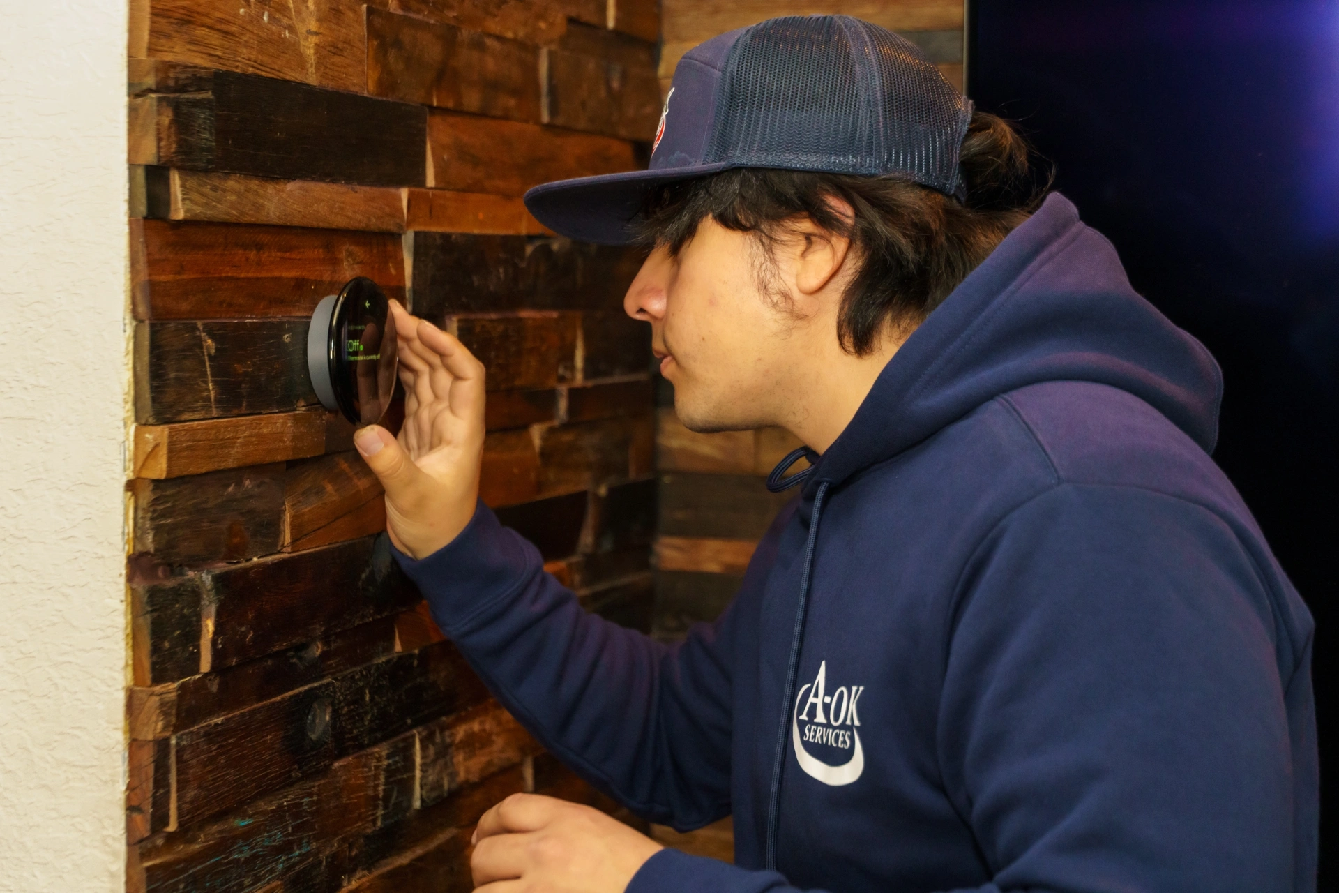 A-OK Services Technician Installing Smart Thermostat for Heating Control