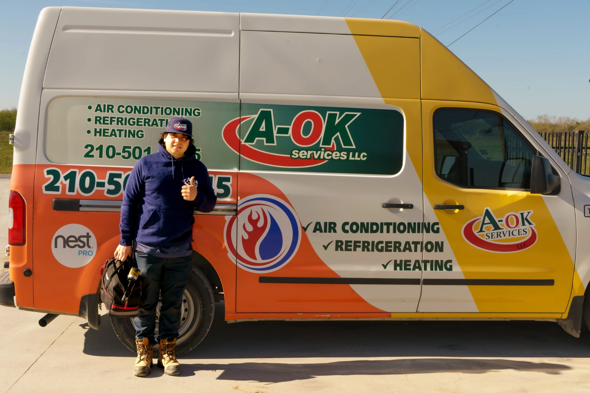 A-OK Services heating maintenance technician with service vehicles in Elmendorf TX